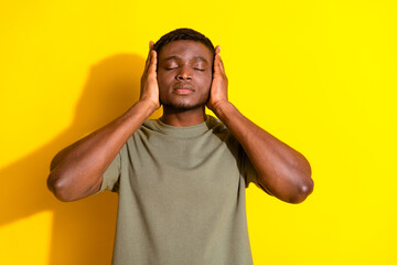 Photo of handsome man wear khaki stylish clothes close ears isolated on yellow color background