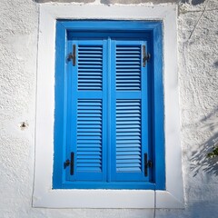Fototapeta premium A plain blue shuttered window on a white wall in Naxos Greece