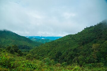 A lush green mountain range with a cloudy sky