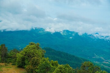 Obraz premium The sky is cloudy and the mountains are green