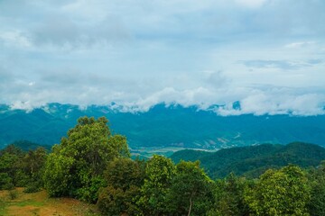 Obraz premium A mountain range with a cloudy sky in the background