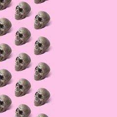 Halloween skull pattern on pink background. Minimal holiday concept.