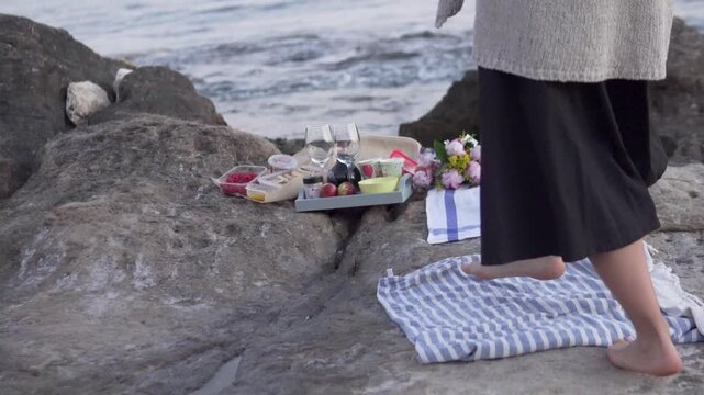 Romantic picnic with food of two female friends on the seashore