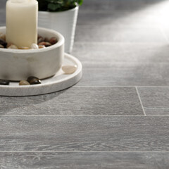 Tranquil Grey Tile Flooring with Decorative Candles, Stones, and Potted Plants in a Zen-inspired setting
