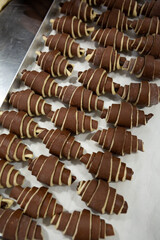 Preparing raw croissants for baking