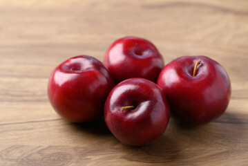 Red plum fruit on wooden background