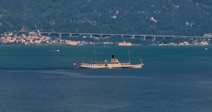 Water transport in Switzerland. Navigating a Swiss Lake. Aerial view steamboat ship on lake Interlaken. Switzerland summer tourism destination. Turquoise blue water. Swiss flag on a passenger ship