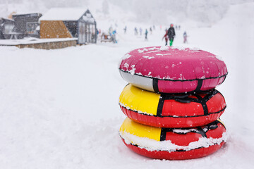 Several colored inflatable snow tubing on the mountainside on a winter day.