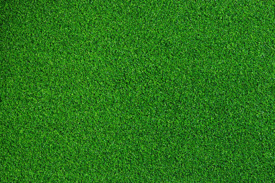 Artificial grass, covering. Artificial green grass mat, top view. Texture. Background. Artificial turf, surface made of synthetic fibers. Flat green grass texture background. Short grass