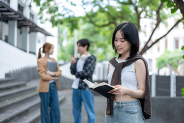 A woman is reading a book while two other people look on