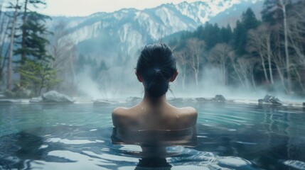 Obraz premium Back view of a female in spa pool with beautiful scenic view