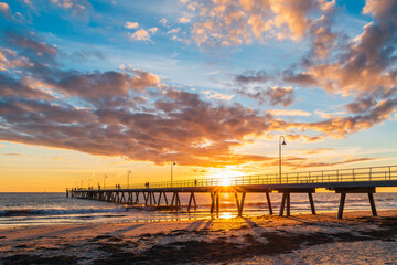 People walking on Glenelg Beach jetty during beautiful sunset, South Australia