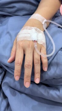 Drop of saline solution drip into patients arm in the hospital.
