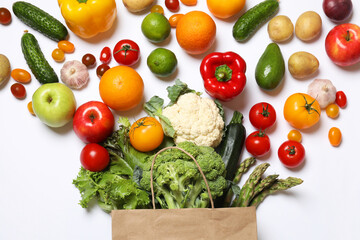 Delivery of vegetarian products. Bag with different vegetables and fruits on white background, top view