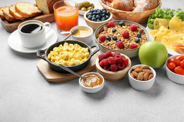 Tasty breakfast. Many different food and drinks on grey textured table