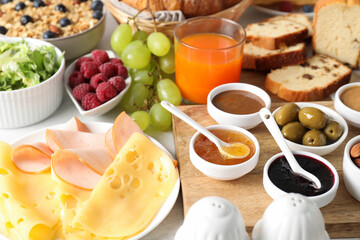Different meals served for breakfast on white table, closeup. Buffet menu