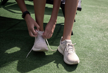 Athlete Tying Laces on Running Shoes. A close-up shot of an athlete tying the laces on a pair of...