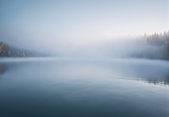 Fototapeta premium Serene Morning Mist Over Tranquil Lake Surrounded by Lush Forest in Autumn