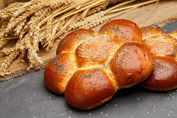 Freshly baked braided challah bread topped with sesame and poppy seeds, perfect for any meal