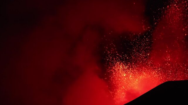 Sicilia - Etna in eruzione con esplosione di lava incandescente con sfondo nero del cielo di sera