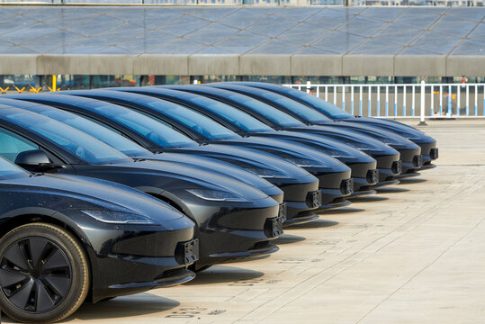 A row of brand new new energy electric cars parked in an outdoor parking lot