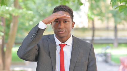 Searching Gesture by African Businessman Outdoor