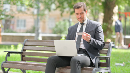 Middle Aged Businessman Upset with Online Banking Problems via Credit Card Outdoor