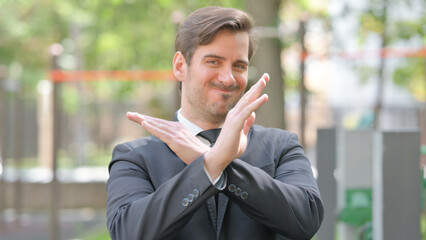 Rejecting Gesture by Tense Young Businessman Outdoor
