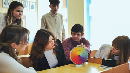 Students in physics class spin Newton's colorful wheel.