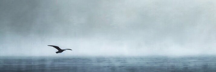 Fototapeta premium Elegant lone bird soaring against an expansive gray sky in a peaceful expression of freedom