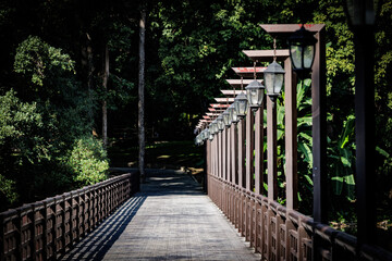 Wooden bridge in the middle of a public park at Ao Kaew, Chiang Mai Province The old lanterns hanging along the bridge cast soft light, casting beautiful shadows on the bridge floor. Suitable for a re