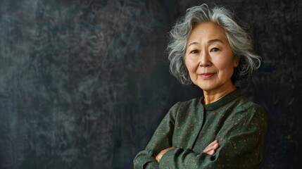 Obraz premium A warm-looking older Asian woman wearing casual clothes, crossing her arms, posing in a friendly manner, and looking at the camera with a sense of success and self-confidence.