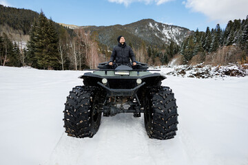 Man is sitting on a huge all-terrain vehicle, a swamp walker, in a snow-covered forest. © Studio Peace