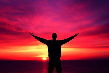 Fototapeta premium Silhouetted Man with Arms Outstretched at Vibrant Sunset, Embracing the Horizon