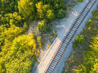 Aerial view of an old railway in the mountains between a dense green forest. International...