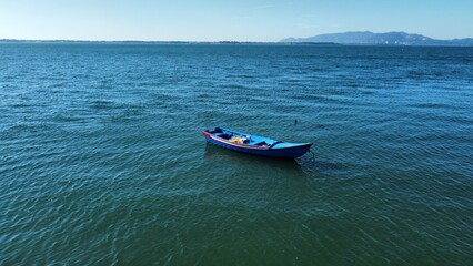 Aerial view of a blue boat on the water.