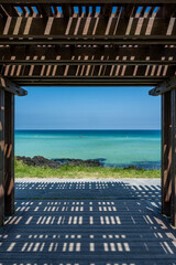 Seaside view from underneath a wooden pergola