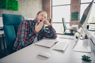 Portrait of young office worker man yawn computer desk wear shirt loft interior business center indoors