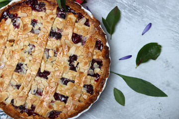 Freshly baked blueberry lattice pie on a table. Beautiful golden crust close up photo. Sweet homemade round cake. Light gray background with space for text. 