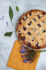 Top view photo of lattice berry pie on a table with summer flowers. Food still life photo. Homemade sweet cake close up. 