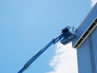 Using a boom truck to work on the roof of a tall building