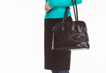 Hand of an elegantly dressed business woman holding black bag