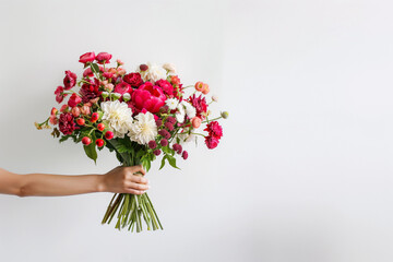 Hand holding bright floral bouquet peonies ranunculus roses wildflowers natural vibrant florist arrangement modern wedding decor organic garden bridal design isolated copyspace