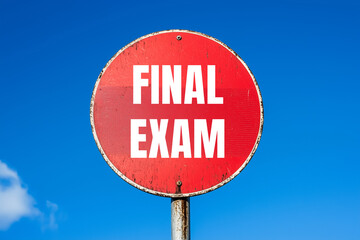 Final exam message written on red round road sign with blue sky background. Conceptual final exam symbol. Copy space.