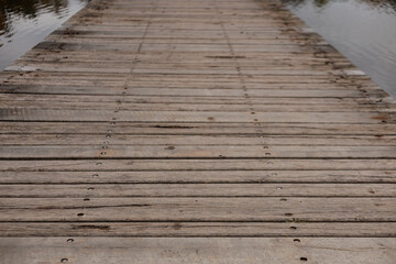 Weathered planks stretch out over serene water autumn in Stromovka park, Prague, Czech republic