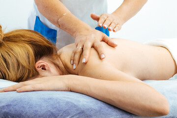 Fototapeta premium Hands of a professional performing a back and neck massage for relaxation. Ideal for demonstrating spa treatments and professional care.