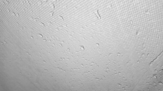 raindrops flow down the silicone durable reinforced rip stop tent awning, light noise and calm. The fabric is waterproof - modern technologies