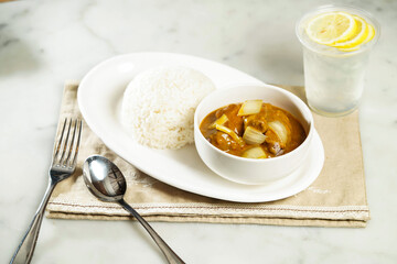 Nostalgic Curry Beef Brisket Rice with lemonade, fork and spoon, served in dish isolated on napkin side view of asian food