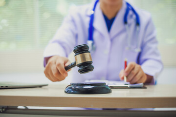 The hammer of justice is a law protecting doctors in diagnosing patients and leading to their death. Hospital insurance considers safety in judgment with lawyers, judges, courts, copy space.