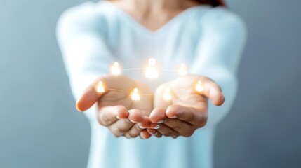 Hands holding glowing lights, symbolizing hope, positivity, energy and inspiration. Close-up of illuminated small figures in open palms.